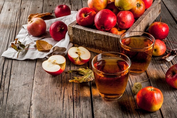 целые и разрезанные яблоки, яблочный сок в стакане